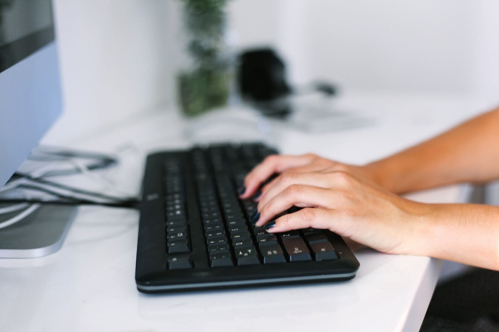 Nosotros 5 womans-hands-typing-on-keyboard-at-desk-working-in-JDKKPMP.jpg